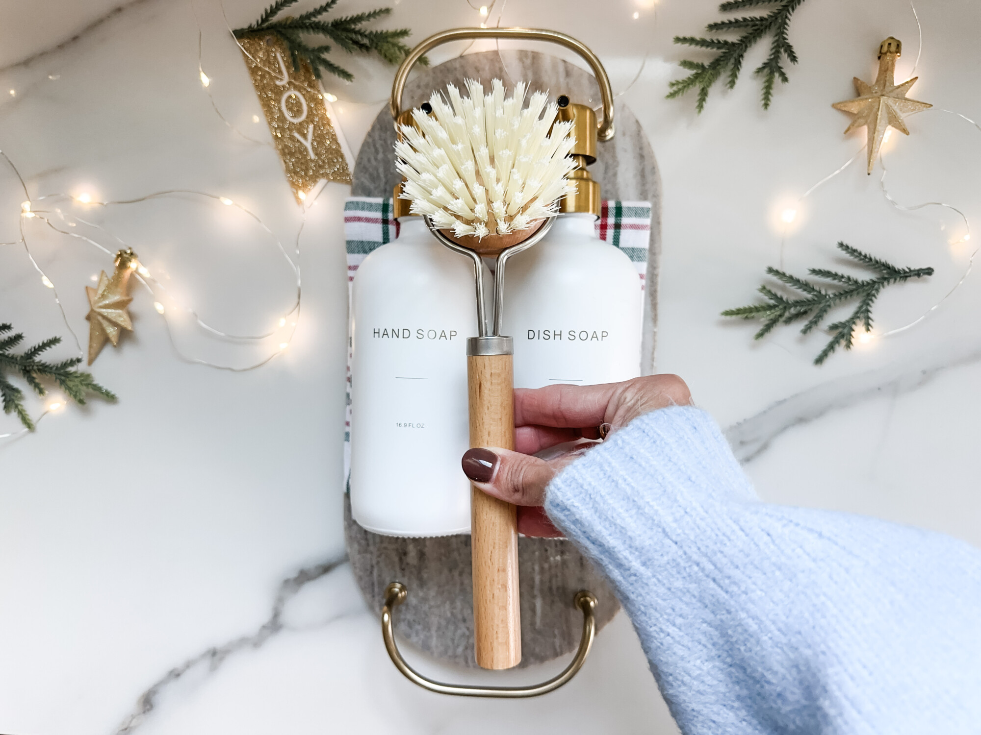 thoughtful and affordable diy host gifts under $35 | host gifts, diy gifts, gift ideas, handmade gift, gift ideas, wood brush, neutral kitchen, gold accessories, soap bottles, plaid towel