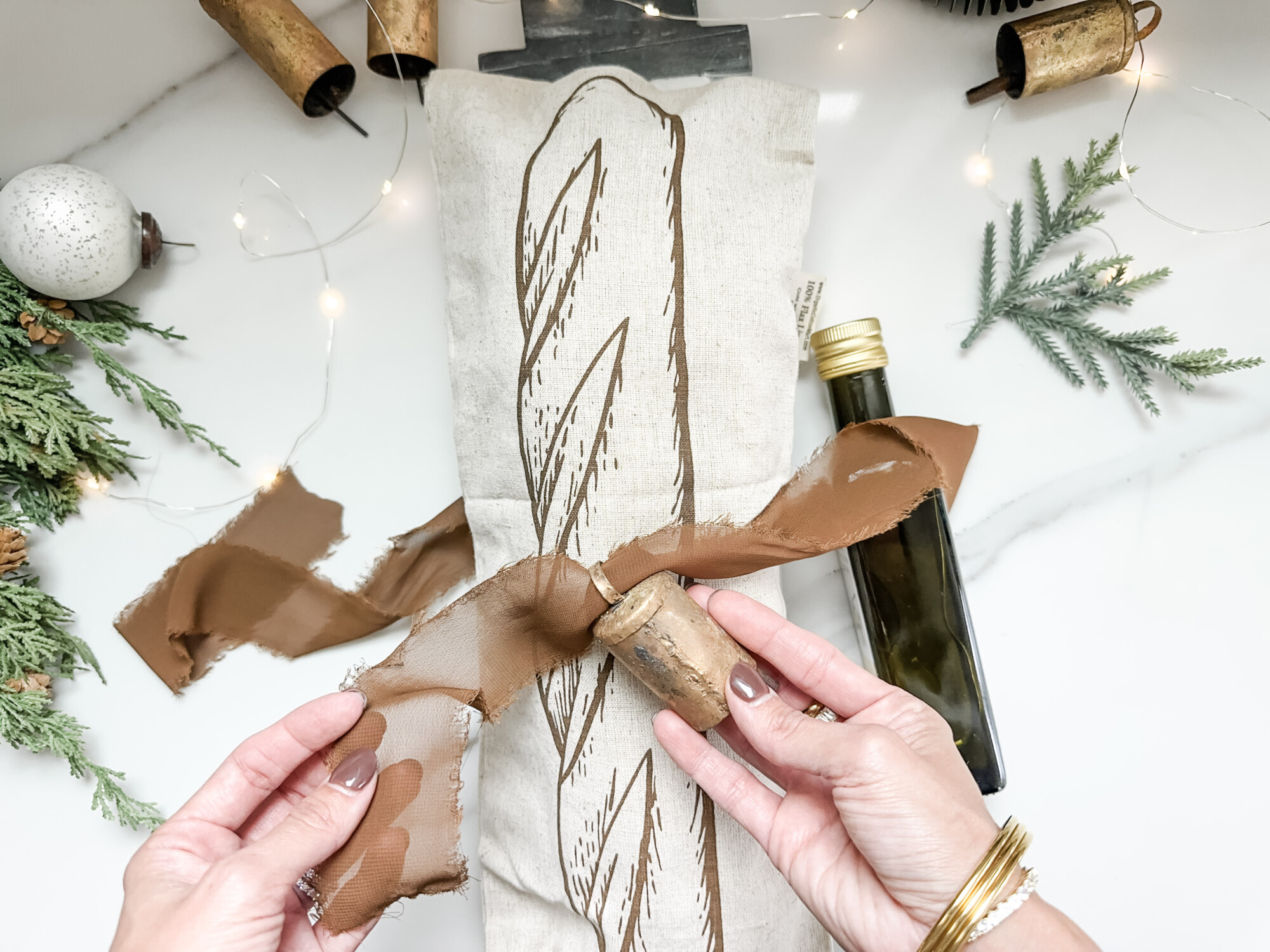 thoughtful and affordable diy host gifts under $35 | host gifts, diy gifts, gift ideas, handmade gift, gift ideas, fringe ribbon, bread oil, snowman tray, garland stems, baguette bag, gold bells, diy bread gift