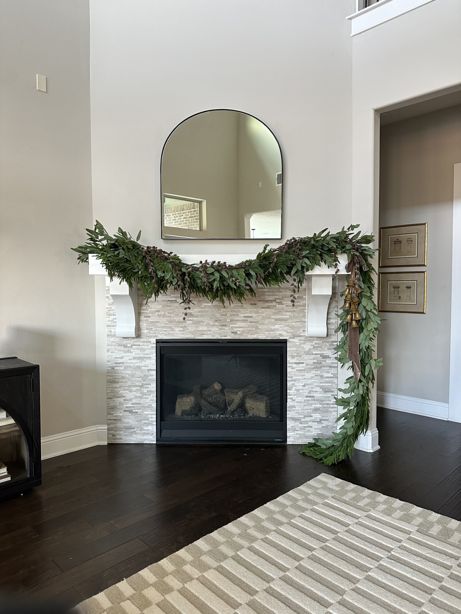 'Tis the Season to Style Your Holiday Mantel | garland, holiday, style, mantel, fireplace, mirror, living room, pine cones, layer, stem, bells, ribbon 