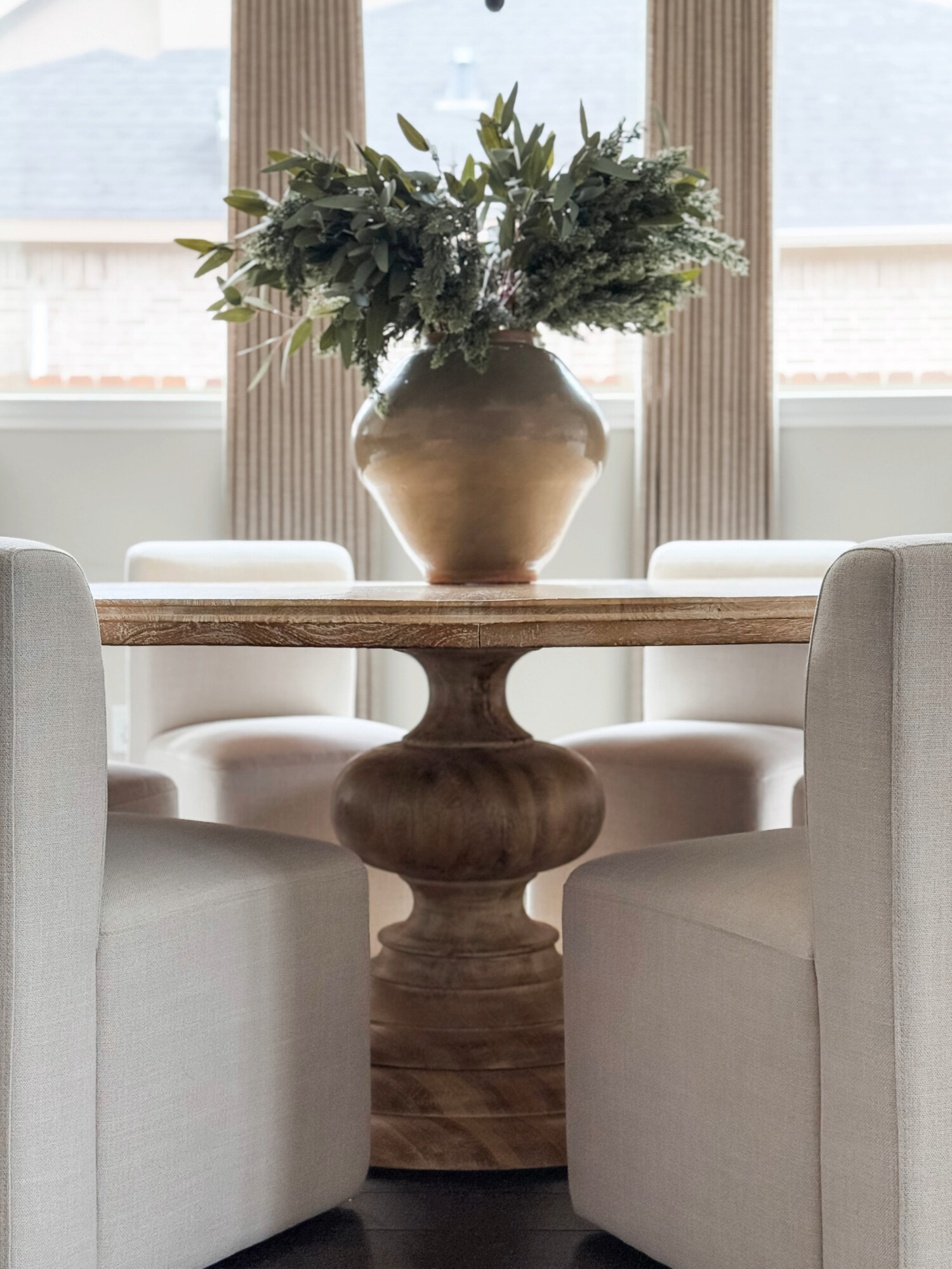 wood circle dining table breakfast nook with white cloth chairs