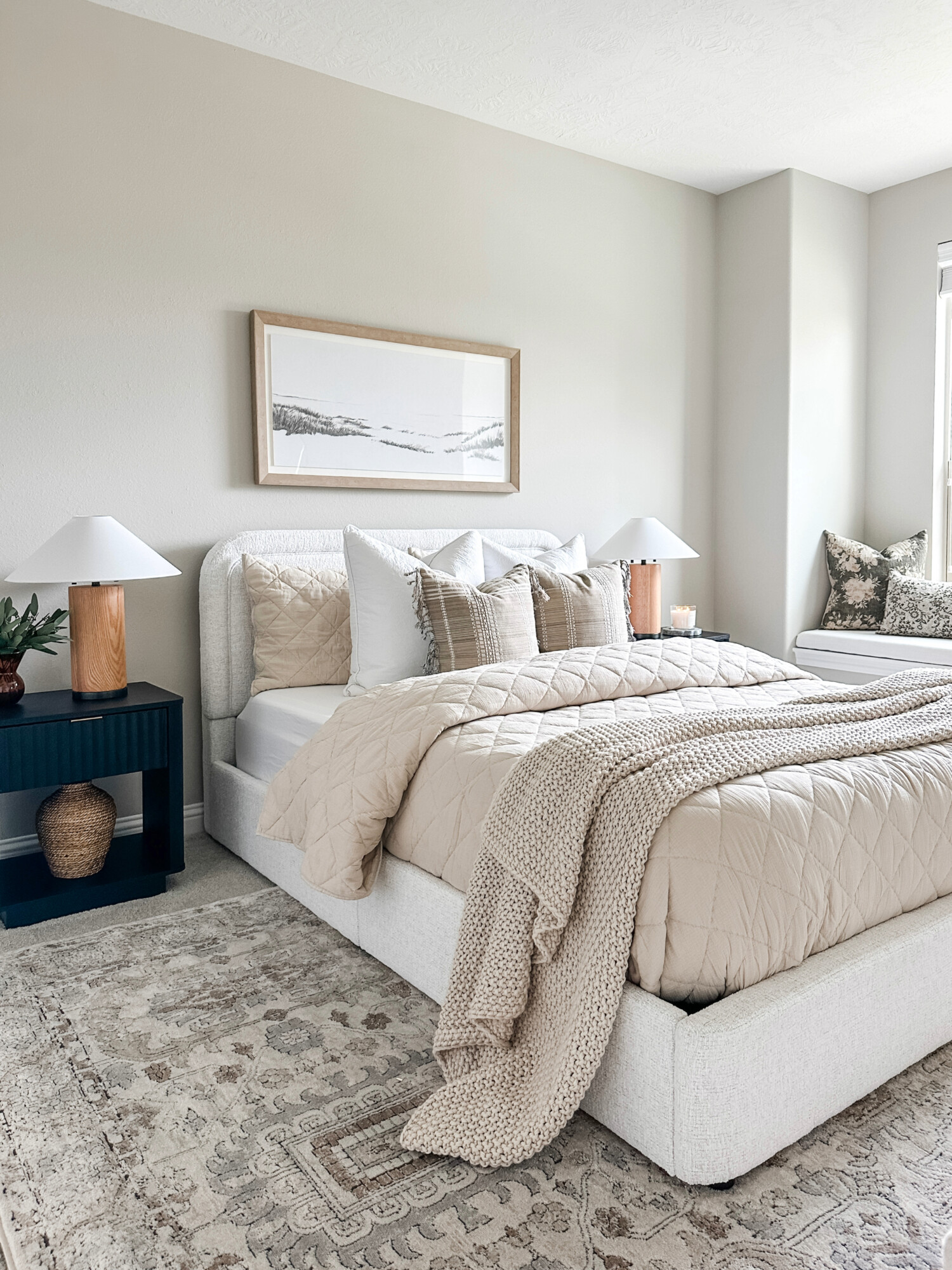 Walmart white upholstered bed with neutral quilt bedding in guest bedroom