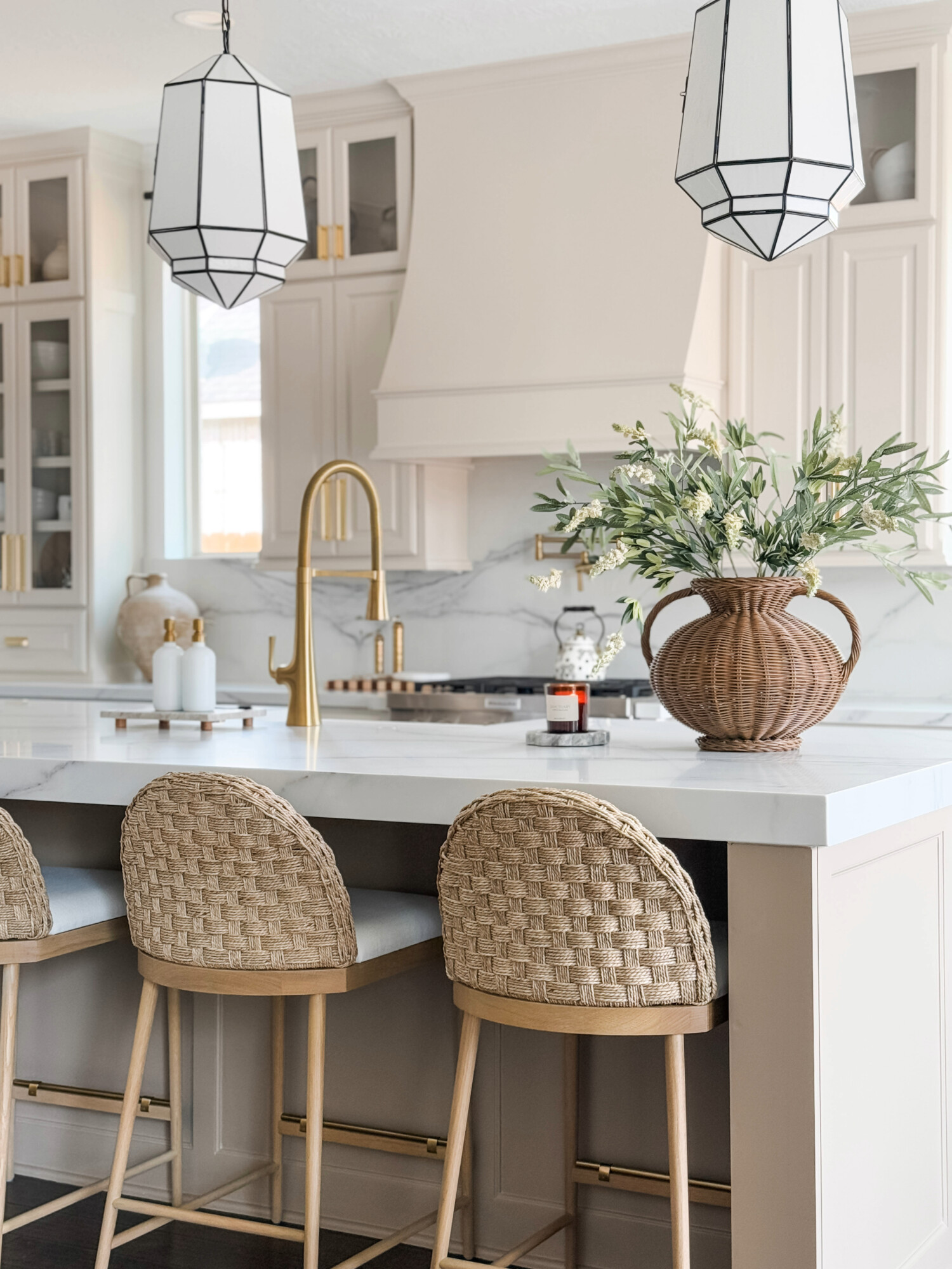 woven barstools in white marble kitchen with wicker vase