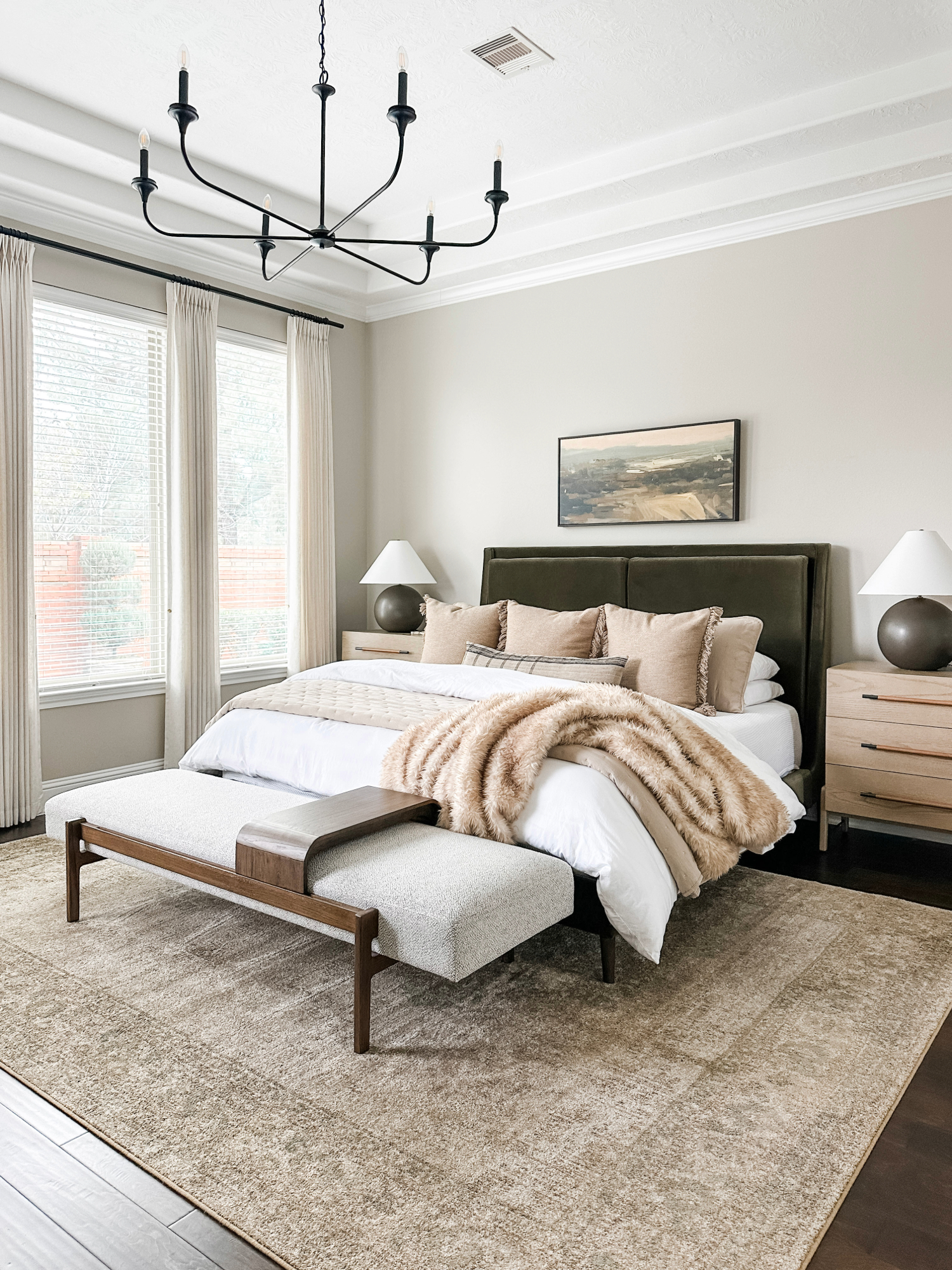 brown fringe throw pillows on master bed and faux fur blanket in beige bedroom