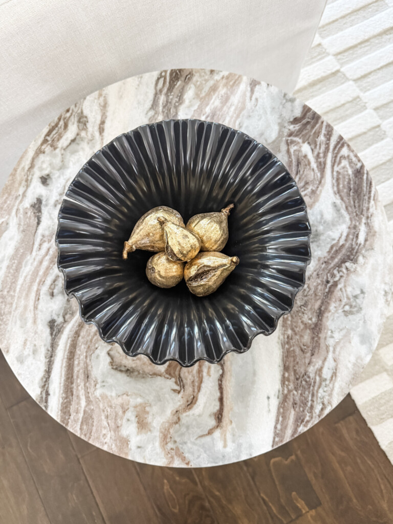 marble end table with decor bowl and gold figs