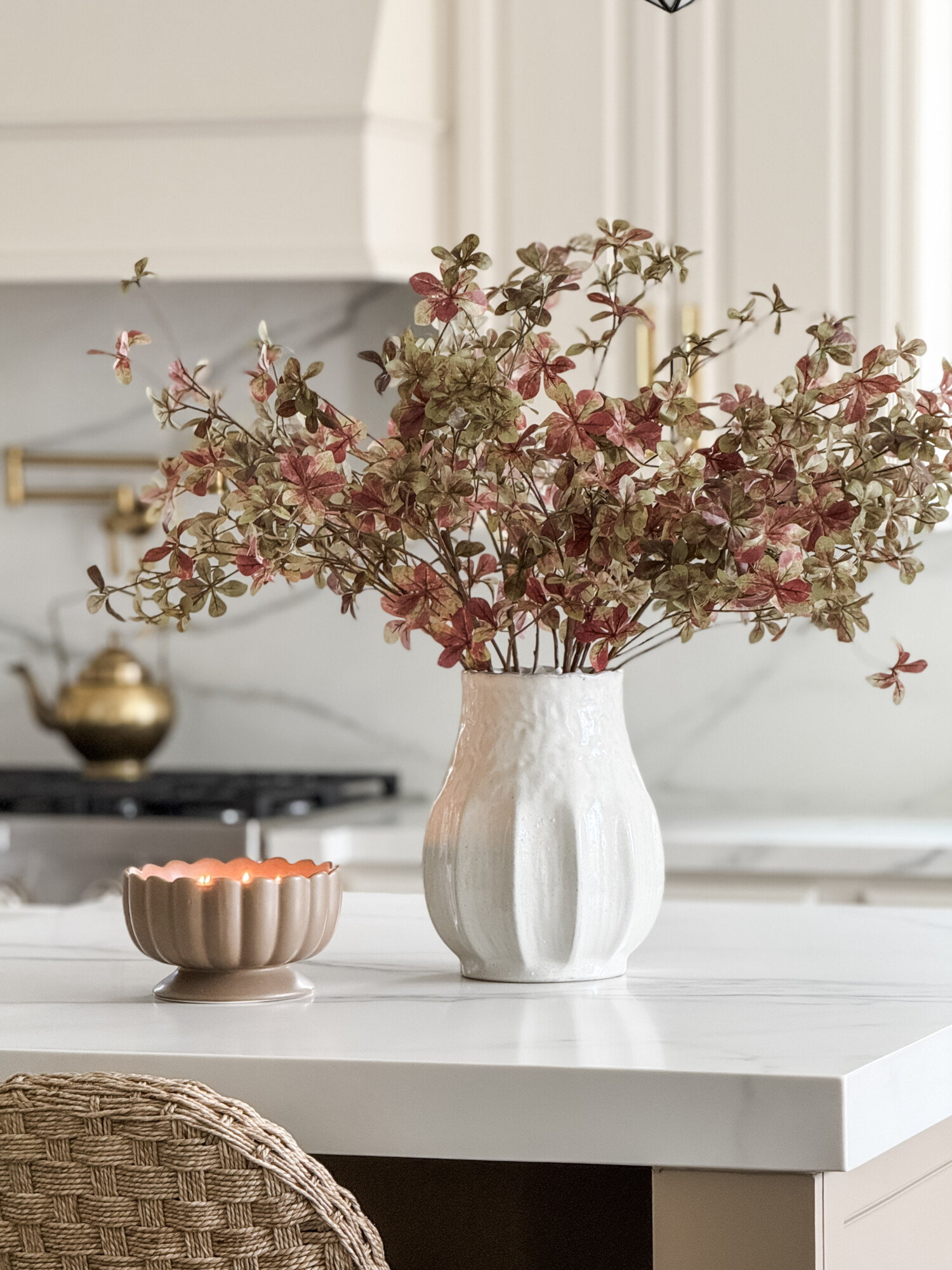 Kitchen counter with fall stems, vase, and candle
